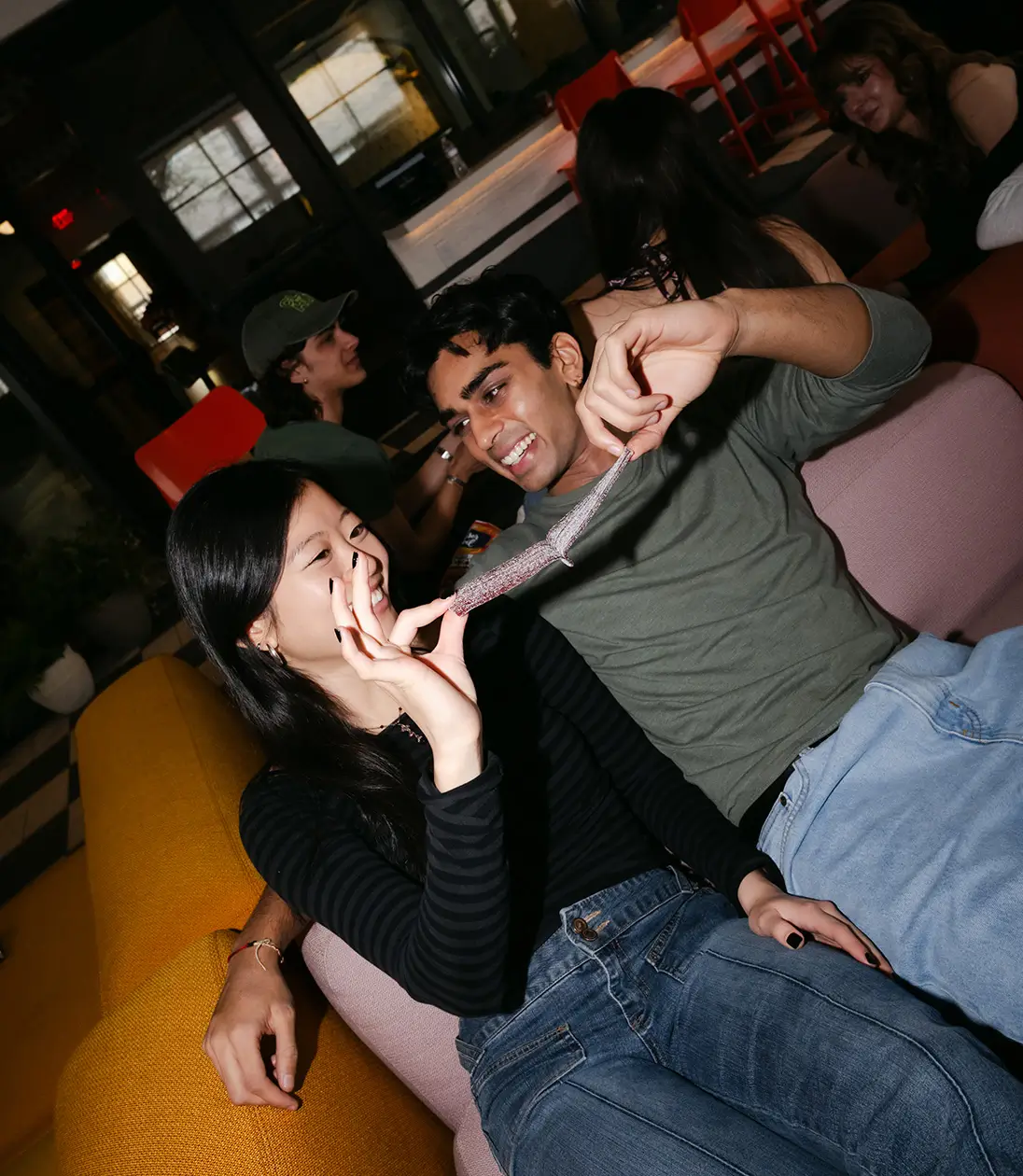 two young adults share a piece of candy
