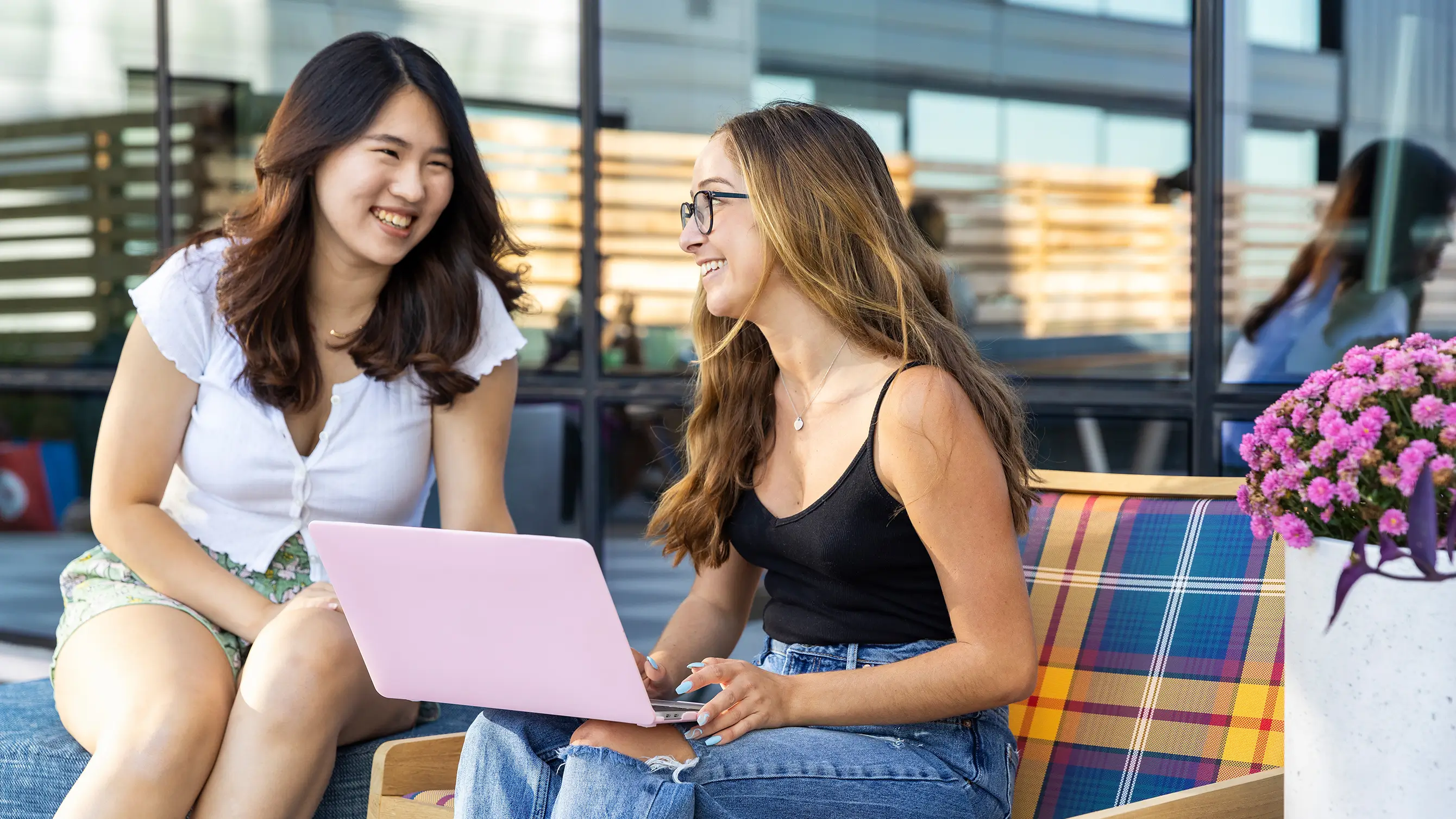 two people using a laptop