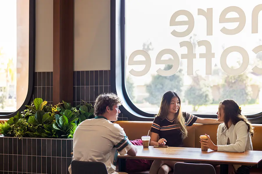 Three people sitting at a coffee shop table