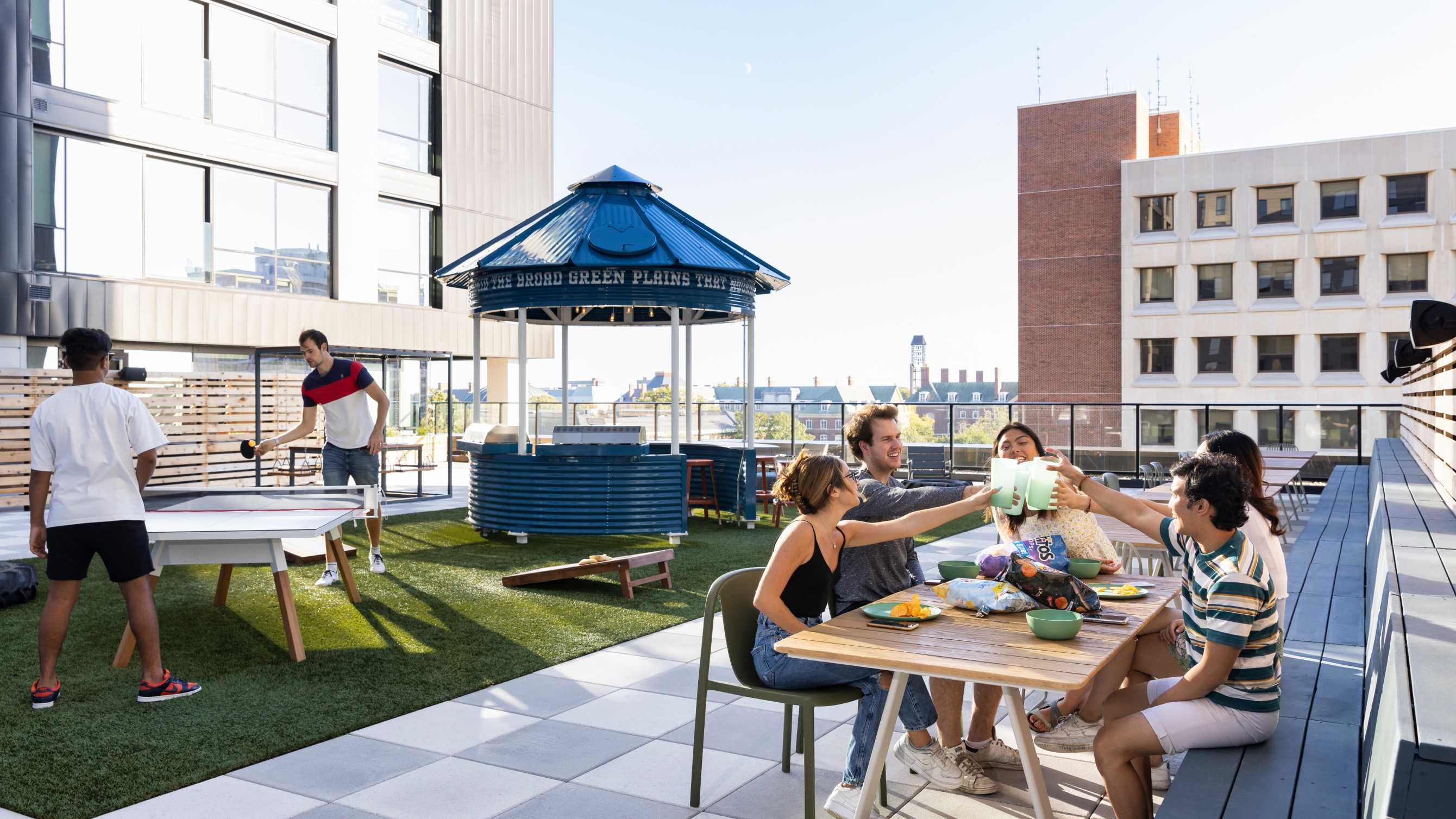 friends playing ping pong and hanging out on rooftop