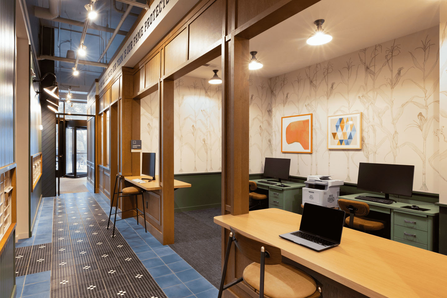 Computer room with various desks and computers and a printer.
