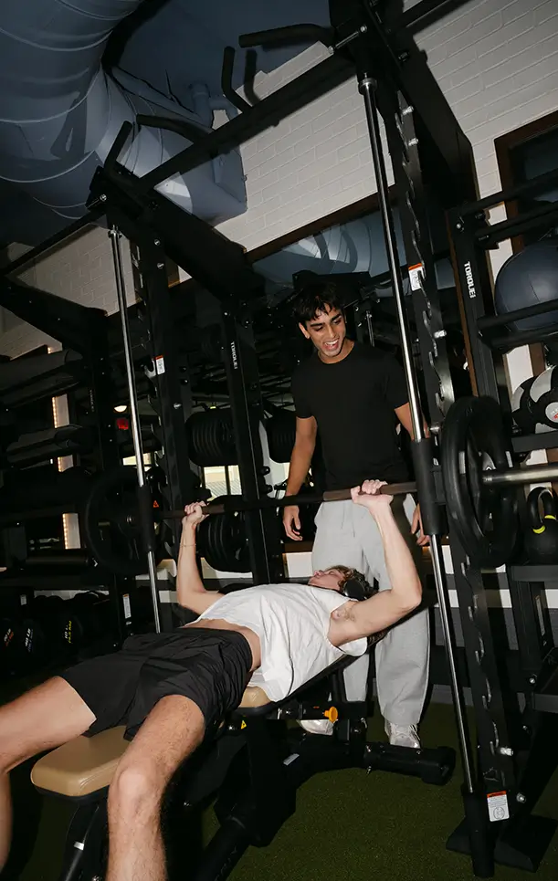 two young men lift weights together