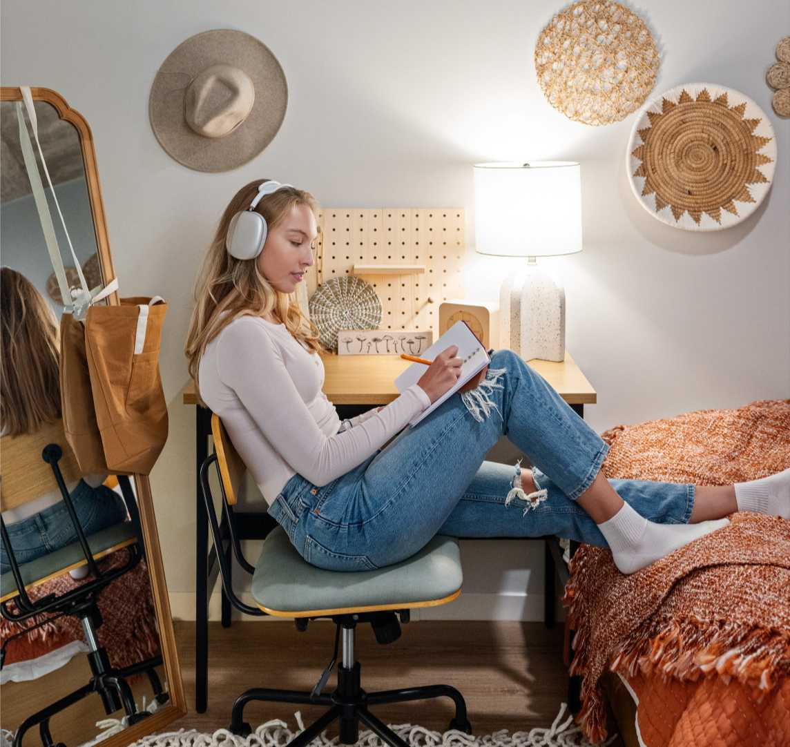 Woman writing in notebook in her room