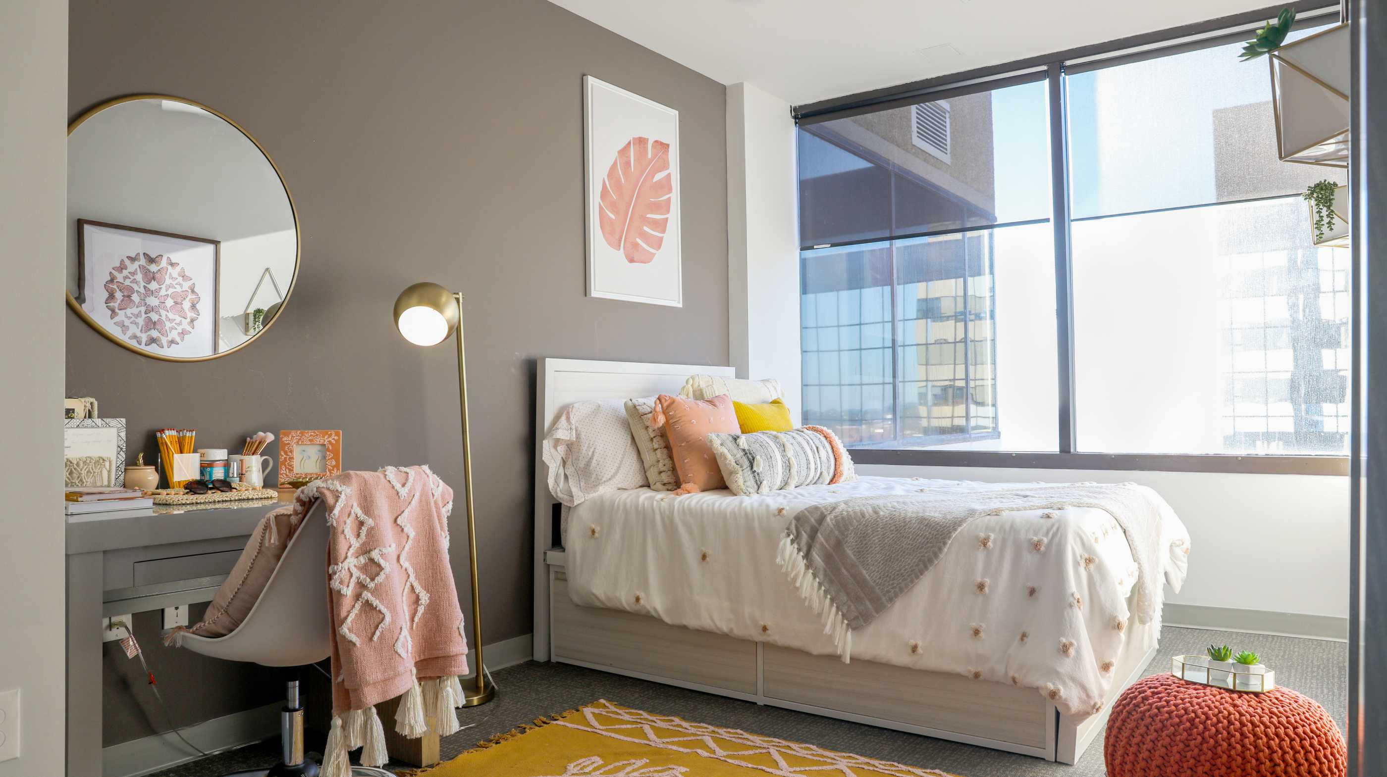 A bedroom with gray walls and a white bed