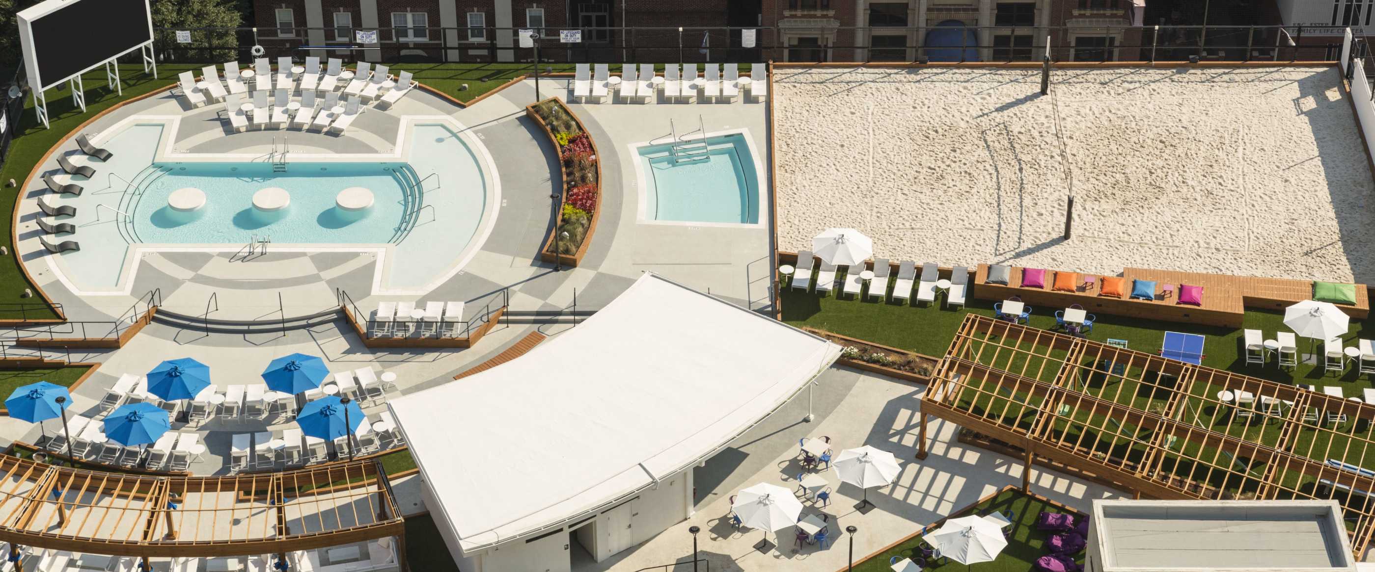 Aerial view of white umbrellas and chairs near a swimming pool