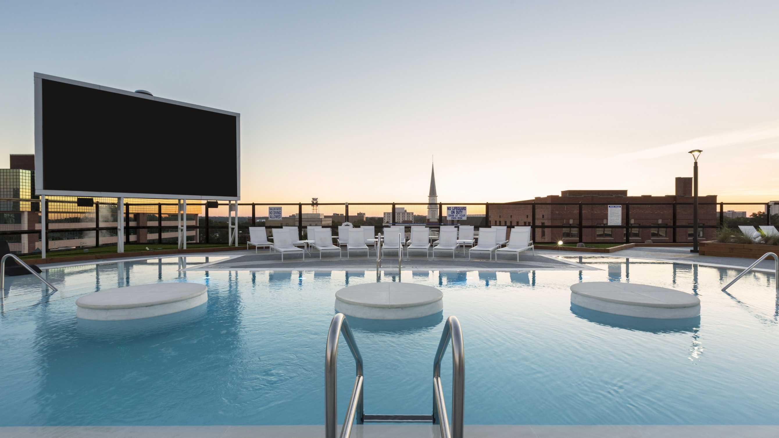 Swimming pool next to white poolside chairs