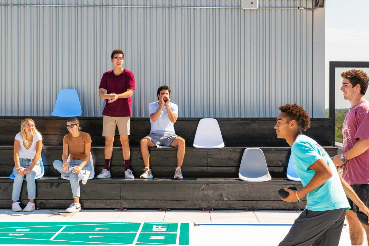Young adults cheering each other on while playing an outdoor game