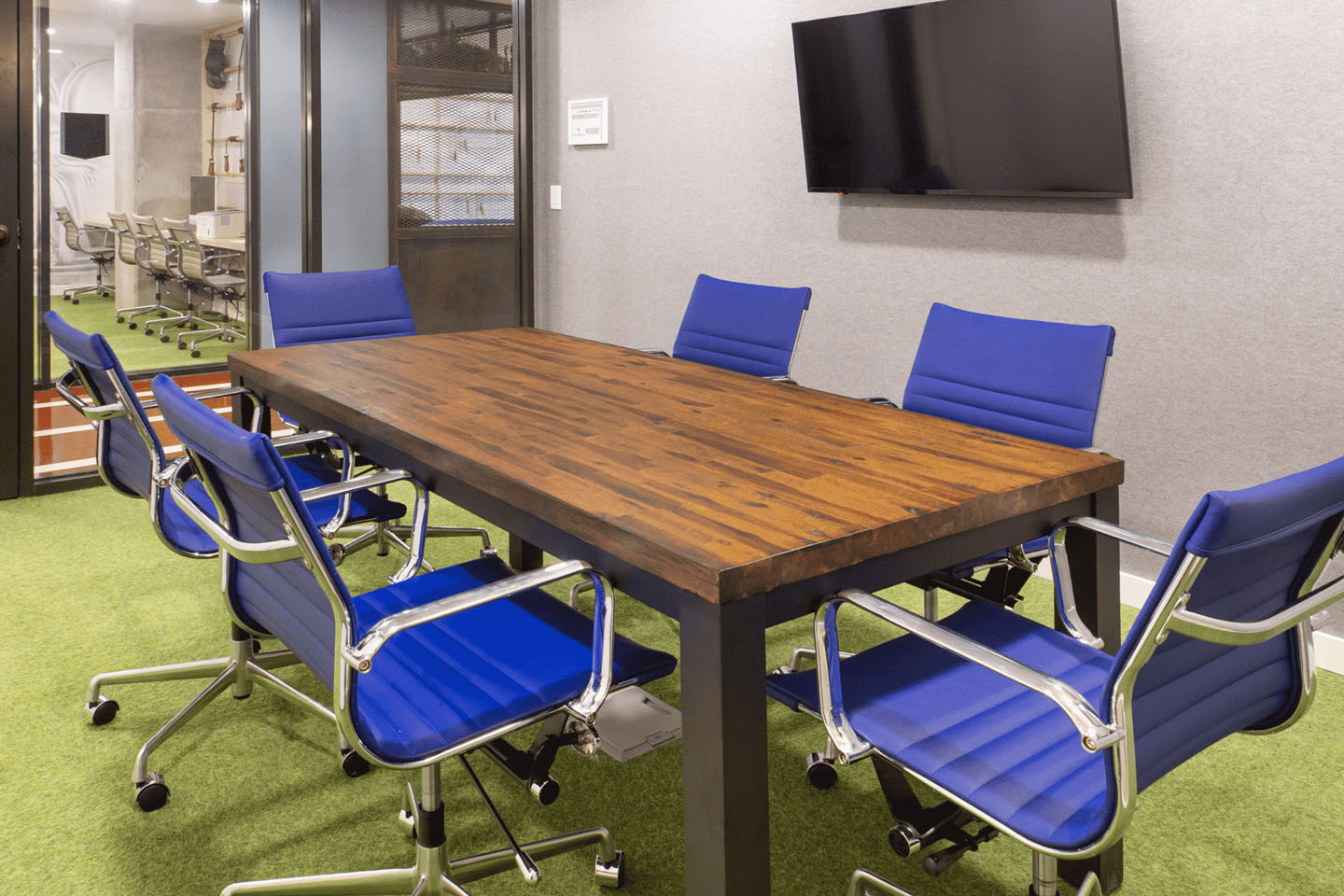 Conference room with a large table and a mounted flat-screen TV