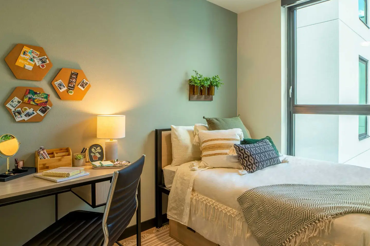 Apartment bedroom with a bed and a desk.