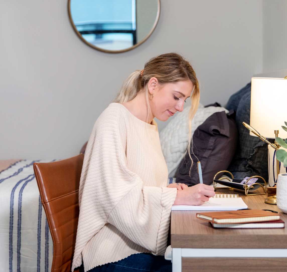 A woman writing in her bedroom