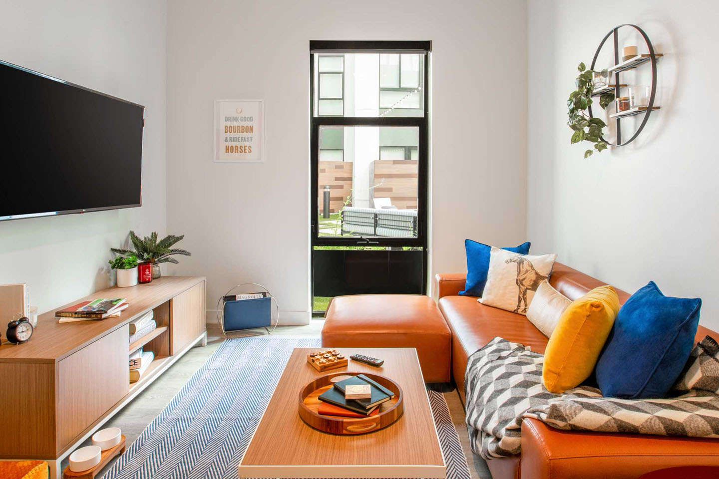 furnished living area with a tv, orange couch, and coffee table.