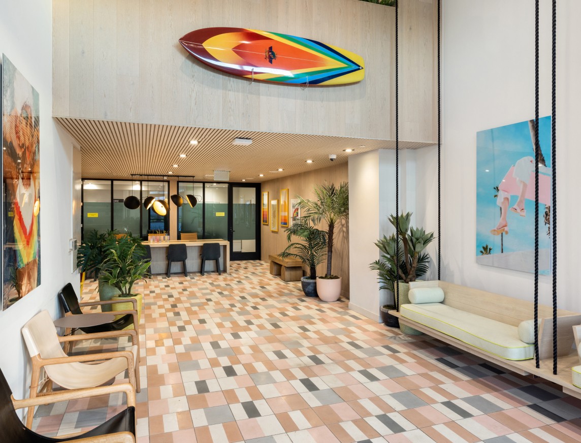 A lobby area with a colorful long board on the wall