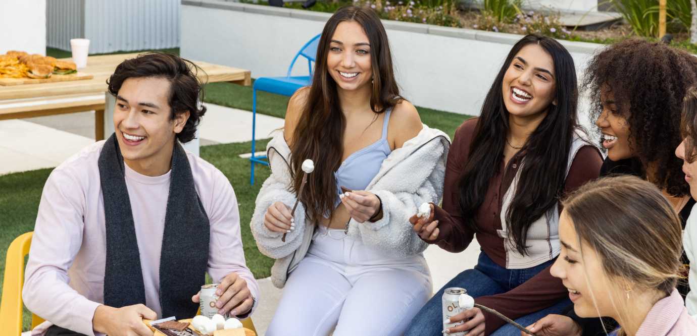 A group of smiling friends making smores