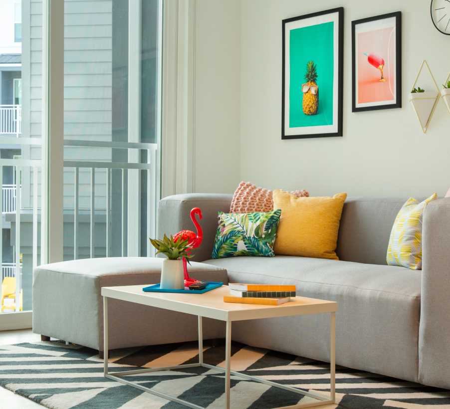 A living room with a gray couch and wall art