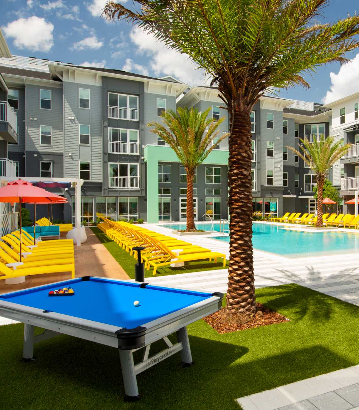 Outdoor pool table next to a palm tree