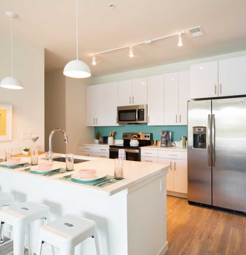 Kitchen with white bar stools and an island