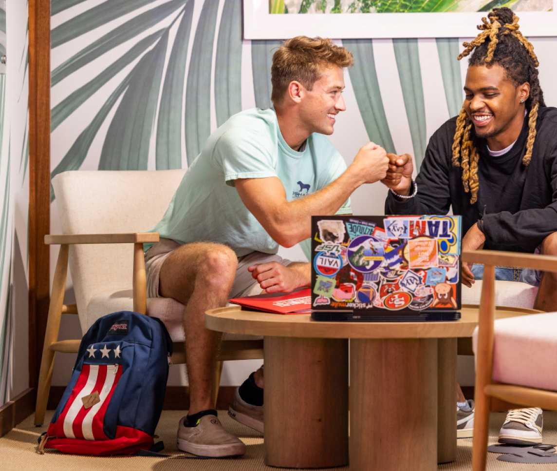 Two friends fist bumping at a table