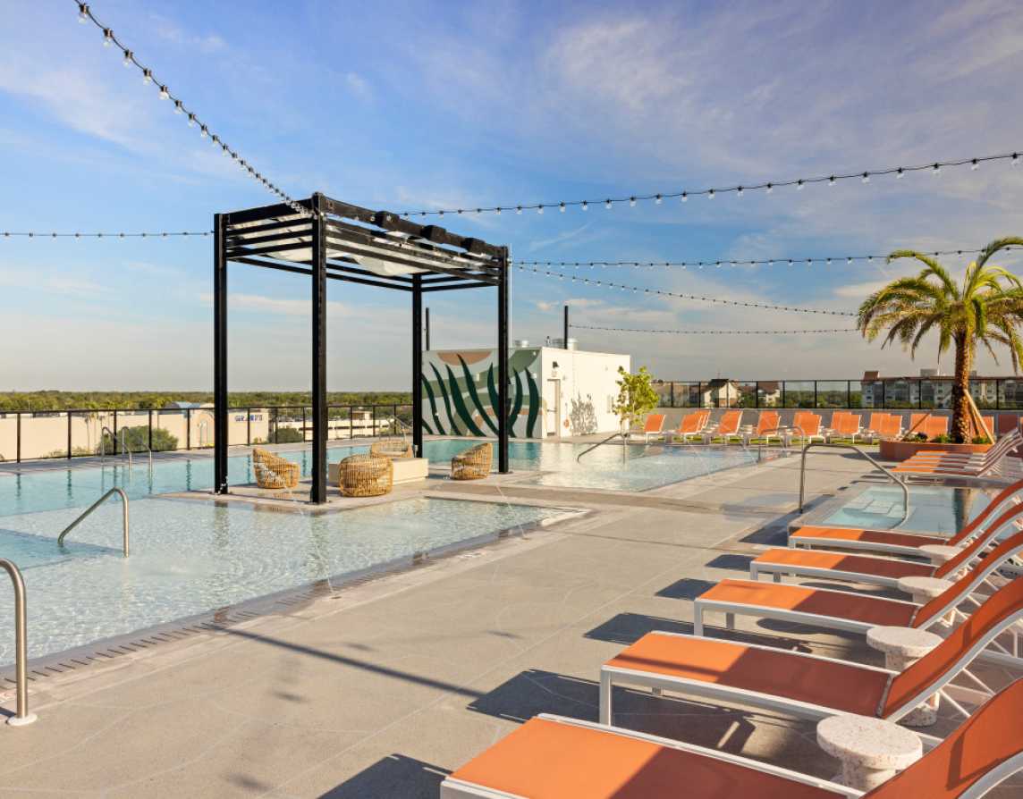 A swimming pool next to orange chairs