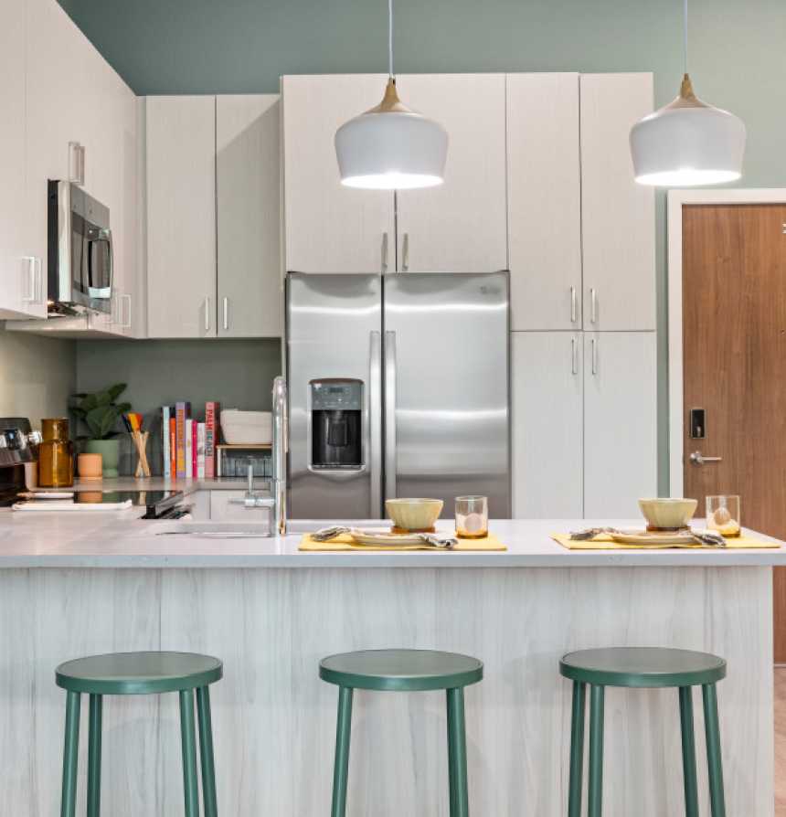 A kitchen with white cabinets and modern appliances