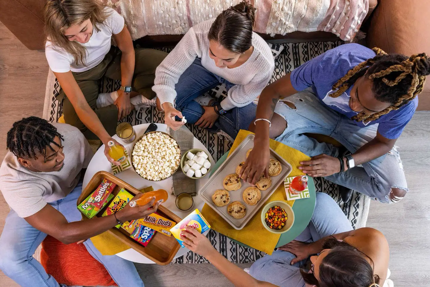 a group of young adults sharing snacks