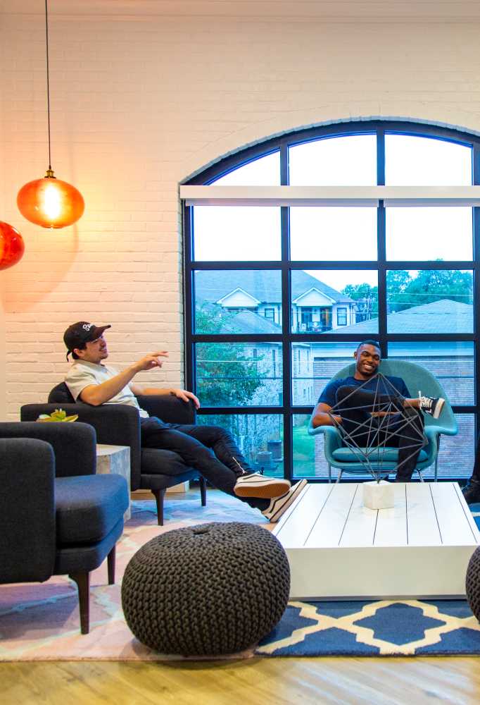 Two friends sitting next to a large window