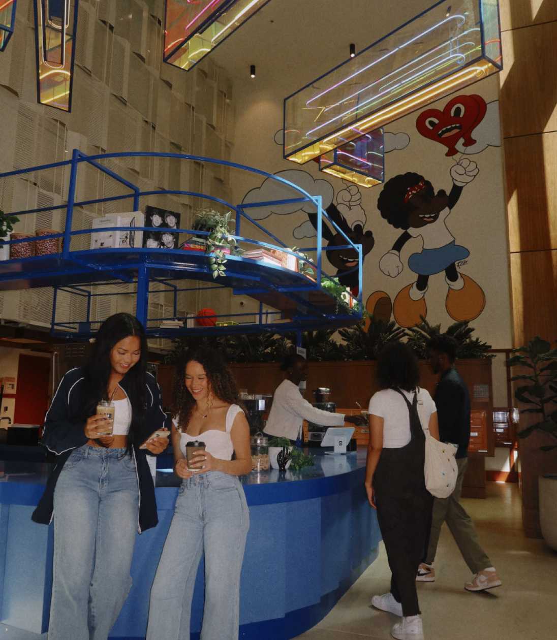 Two friends holding coffee cups in a lobby