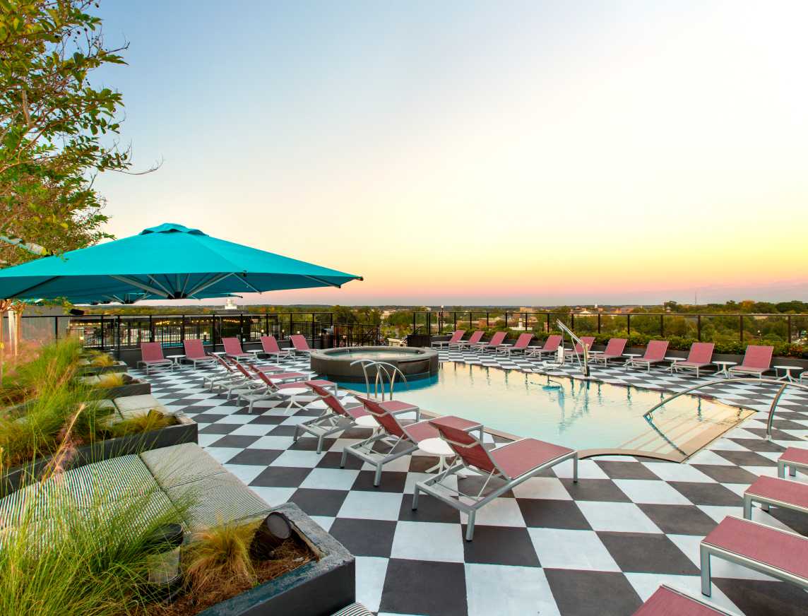 A swimming pool with poolside chairs