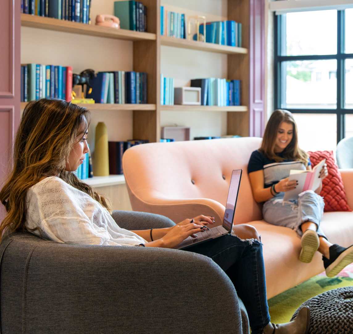 Women reading and typing in a common room